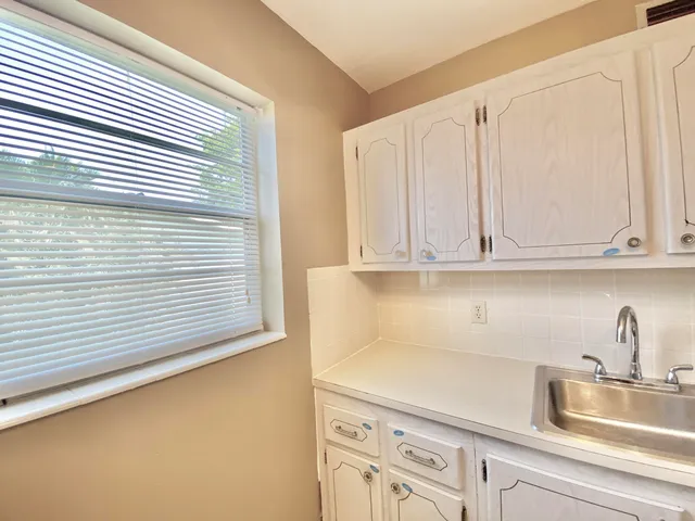 a kitchen with white cabinets and a sink