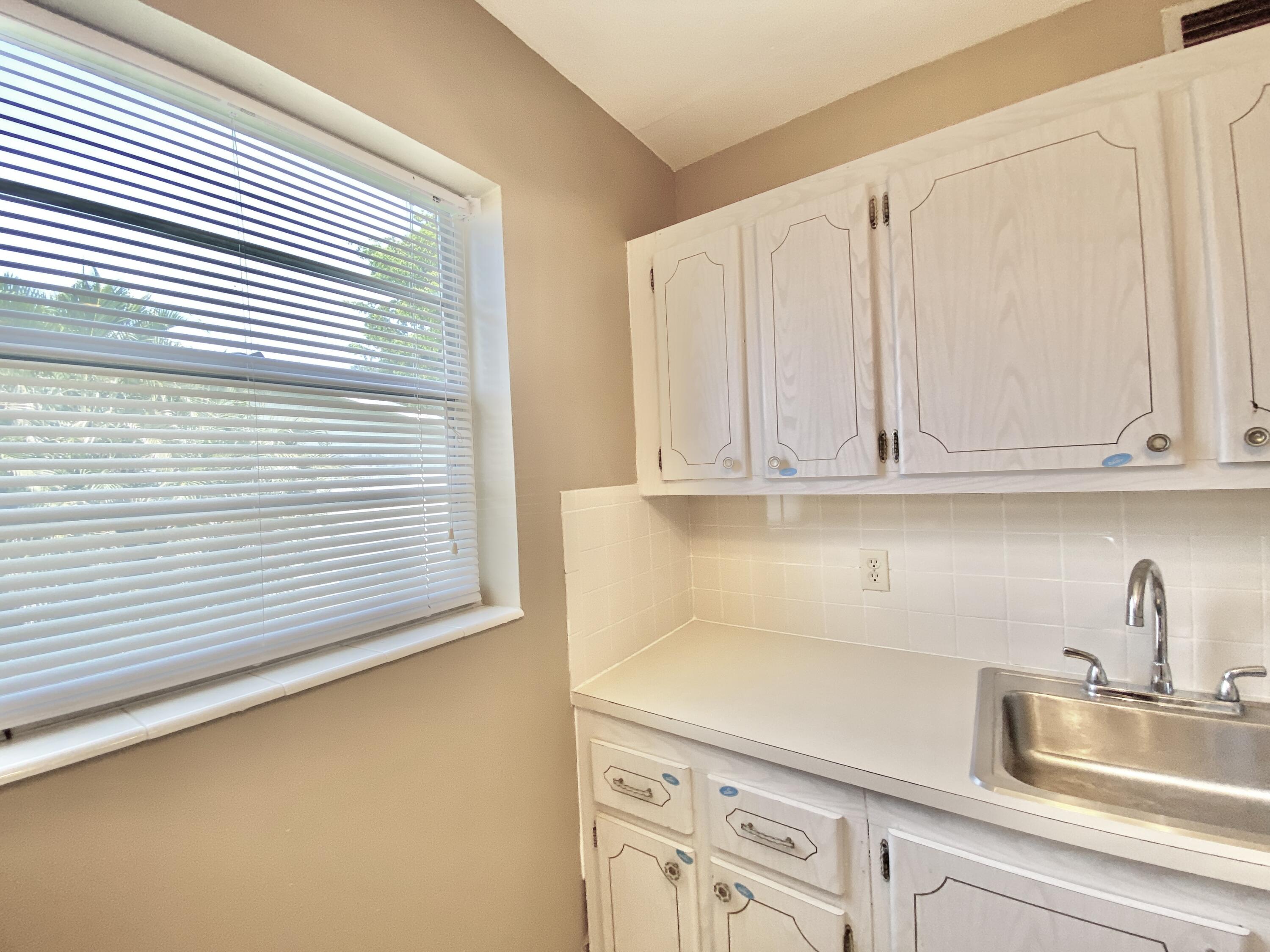a kitchen with white cabinets and a sink