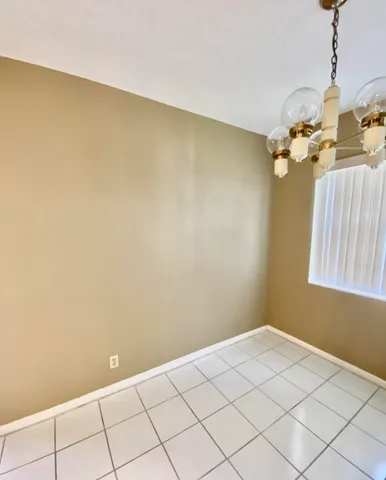 a view of a room with a window and chandelier fan