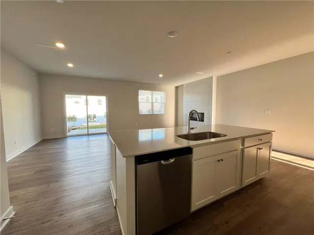 a view of kitchen with stainless steel appliances kitchen island sink and wooden floor
