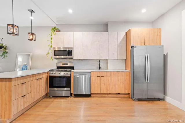 a kitchen with stainless steel appliances granite countertop a refrigerator a sink and a stove