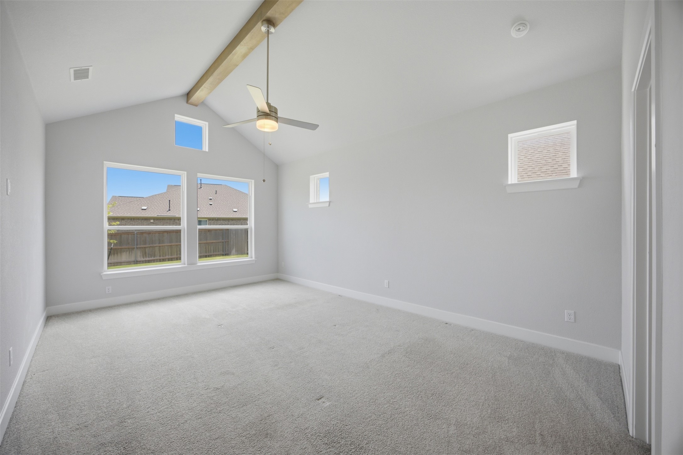 2101 Little Snake Way Georgetown, TX 78633 - Photo 19 of 37 A spacious chamber with lofty vaulted ceilings, showcasing an exposed beam and a ceiling fan, illuminated by multiple windows.