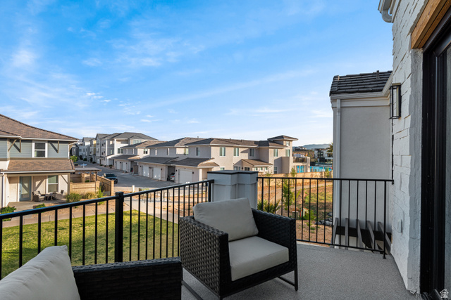 5367 Cyan Lane St. George, UT 84790 - Photo 42 of 49 Balcony space featuring a textured concrete surface, black metal railings, and an exterior wall with white stacked stone detailing
