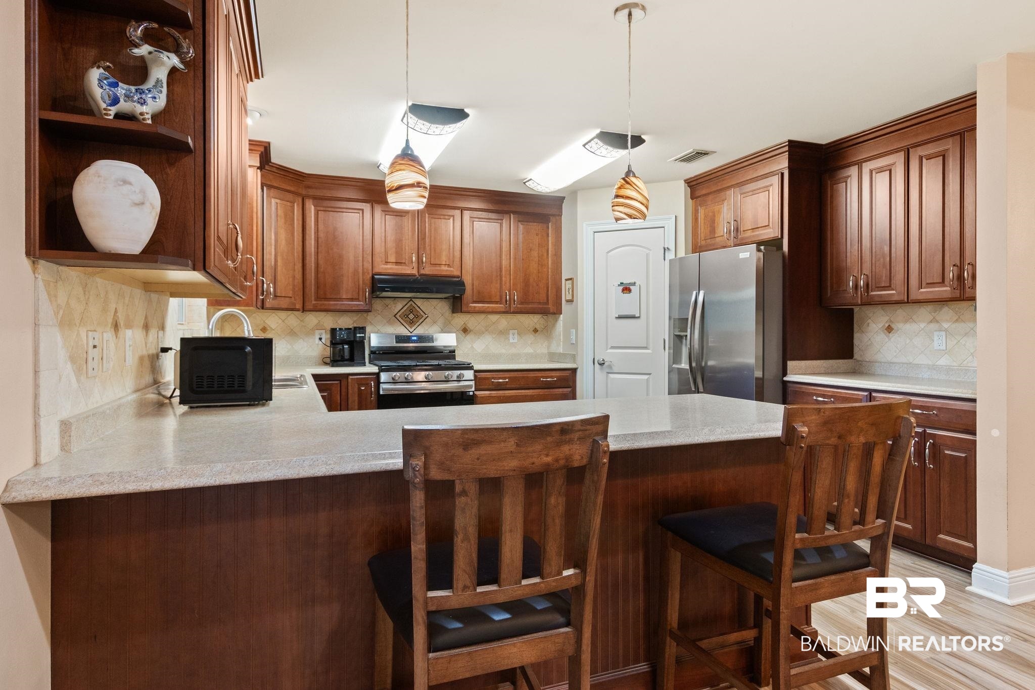 24250 Hack Road Bay Minette, AL 36507 - Photo 13 of 88 Kitchen with stainless steel appliances, a peninsula, a kitchen breakfast bar, open shelves, and light wood-style floors