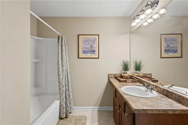 a bathroom with a granite countertop sink a mirror a vanity and a bathtub