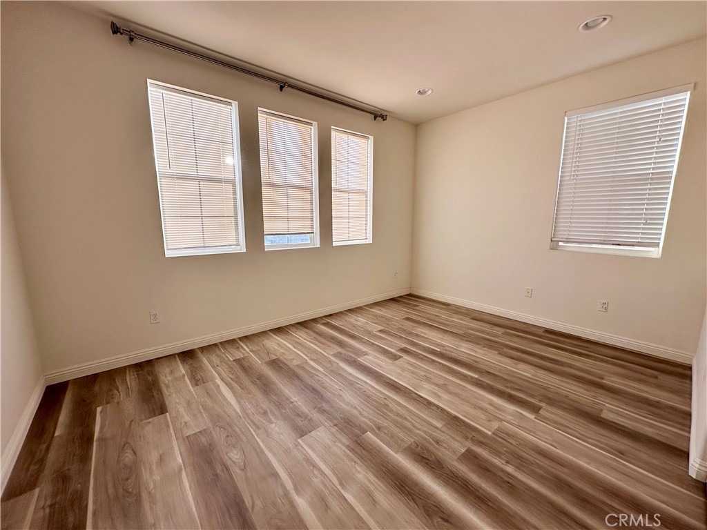 14807 Harmony Lane Westminster, CA 92683 - Photo 8 of 10 a view of an empty room with wooden floor and a window