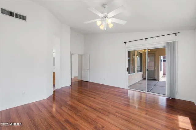 an empty room with wooden floor and window