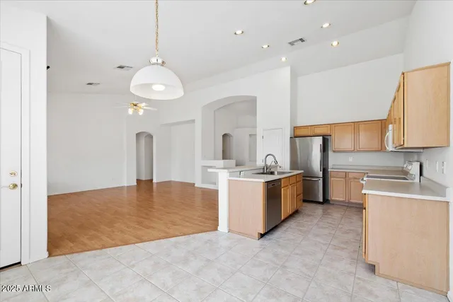 a large white kitchen with a large island oven a stove and a sink
