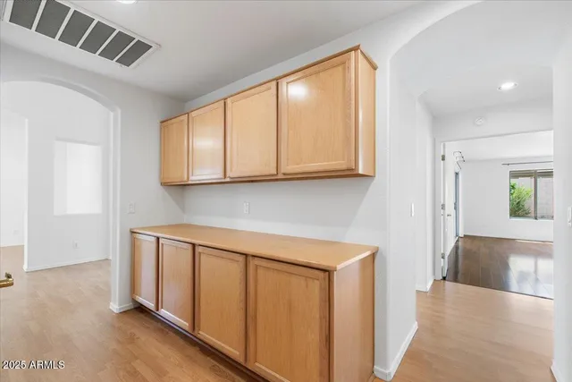 a view of a kitchen with wooden floor and cabinets