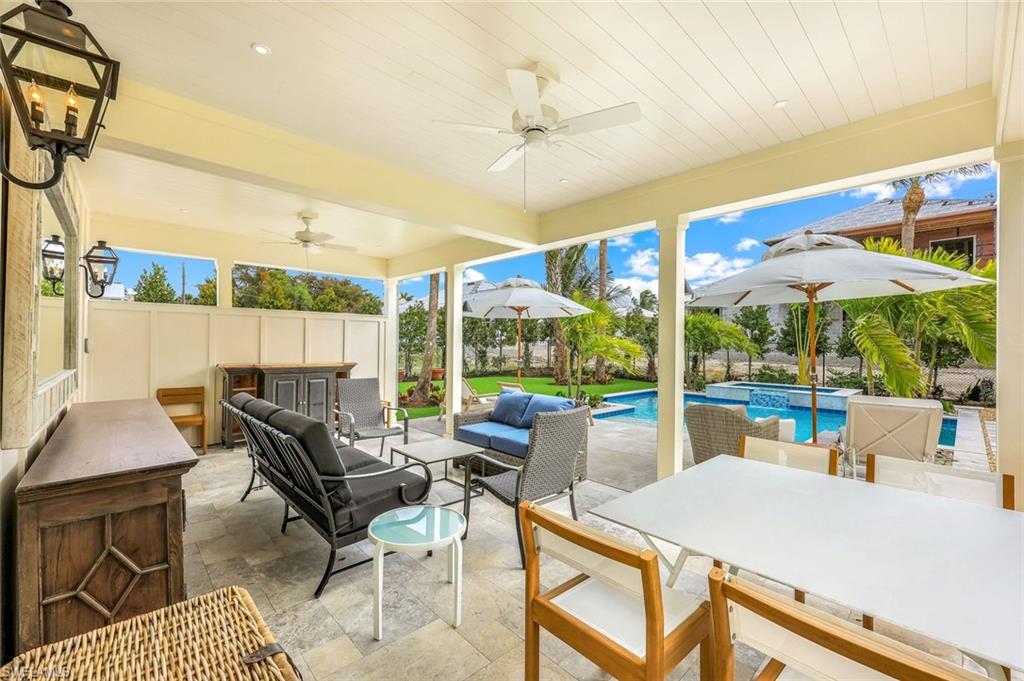 1437 Sandpiper Street Naples, FL 34102 - Photo 20 of 38 a view of a patio with a dining table and chairs