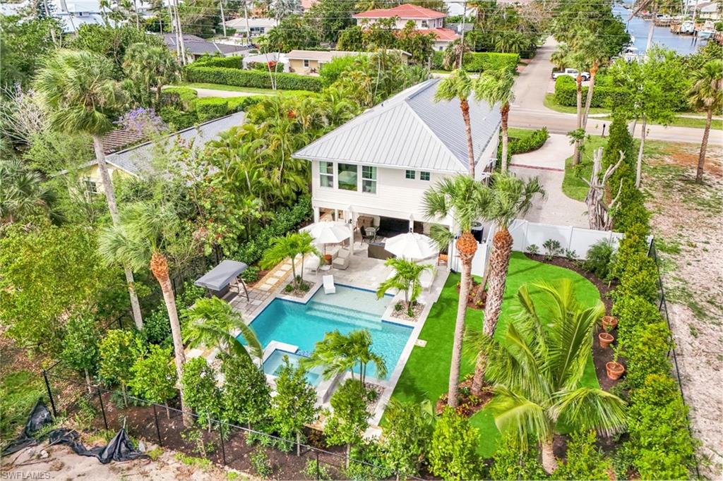 1437 Sandpiper Street Naples, FL 34102 - Photo 2 of 38 an aerial view of a house with a yard and lake view
