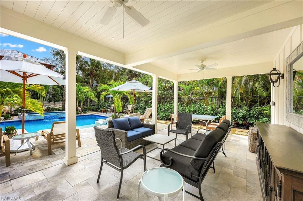 1437 Sandpiper Street Naples, FL 34102 - Photo 21 of 38 a living room with furniture and floor to ceiling windows
