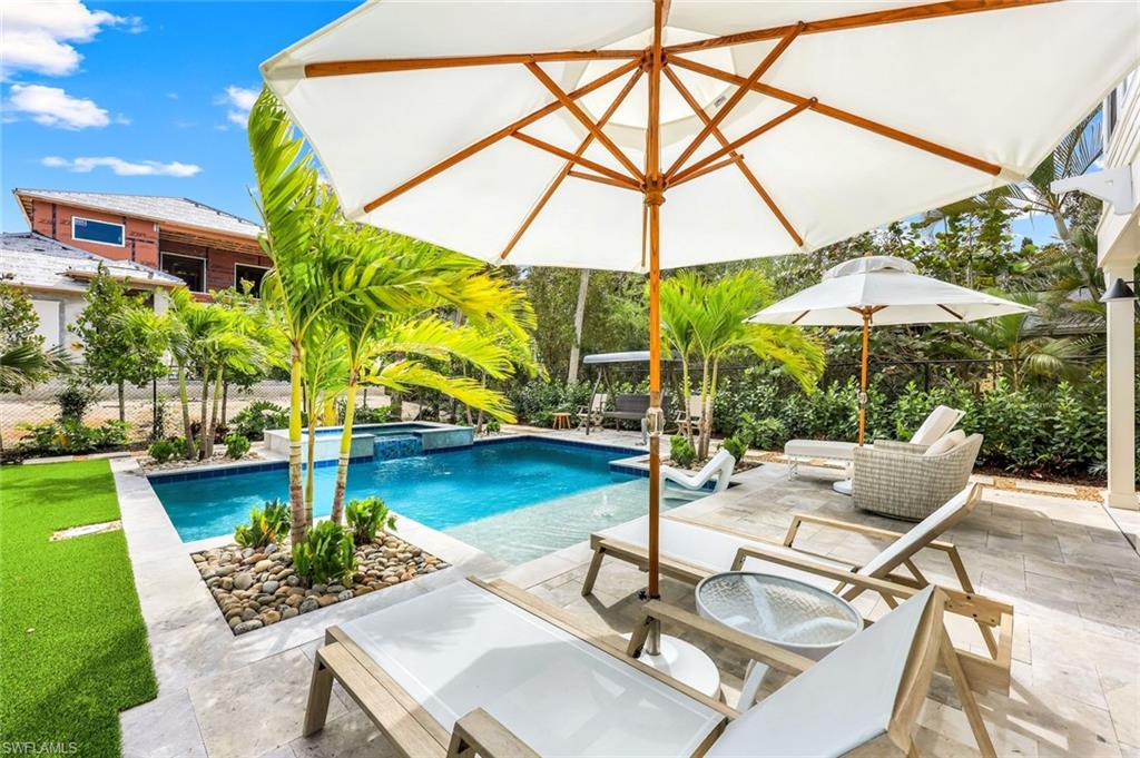 1437 Sandpiper Street Naples, FL 34102 - Photo 24 of 38 a view of swimming pool with lounge chairs
