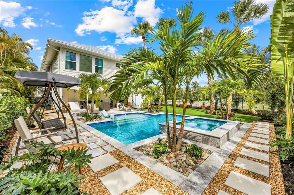 1437 Sandpiper Street Naples, FL 34102 - Photo 25 of 38 a view of a house with pool and sitting area