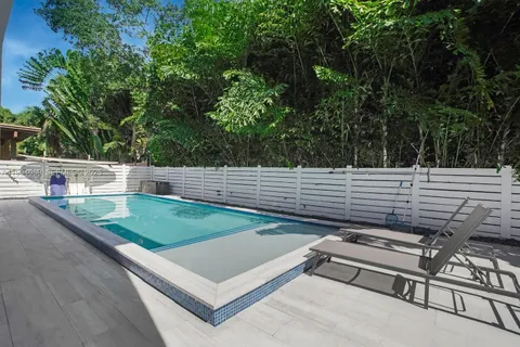 a bedroom with a bed tv and view of living room
