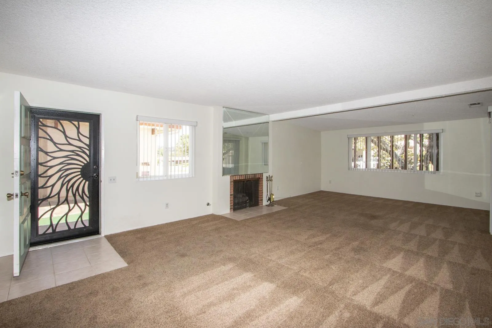 12475 Rios Road San Diego, CA 92128 - Photo 4 of 34 a view of an empty room with a window and fireplace