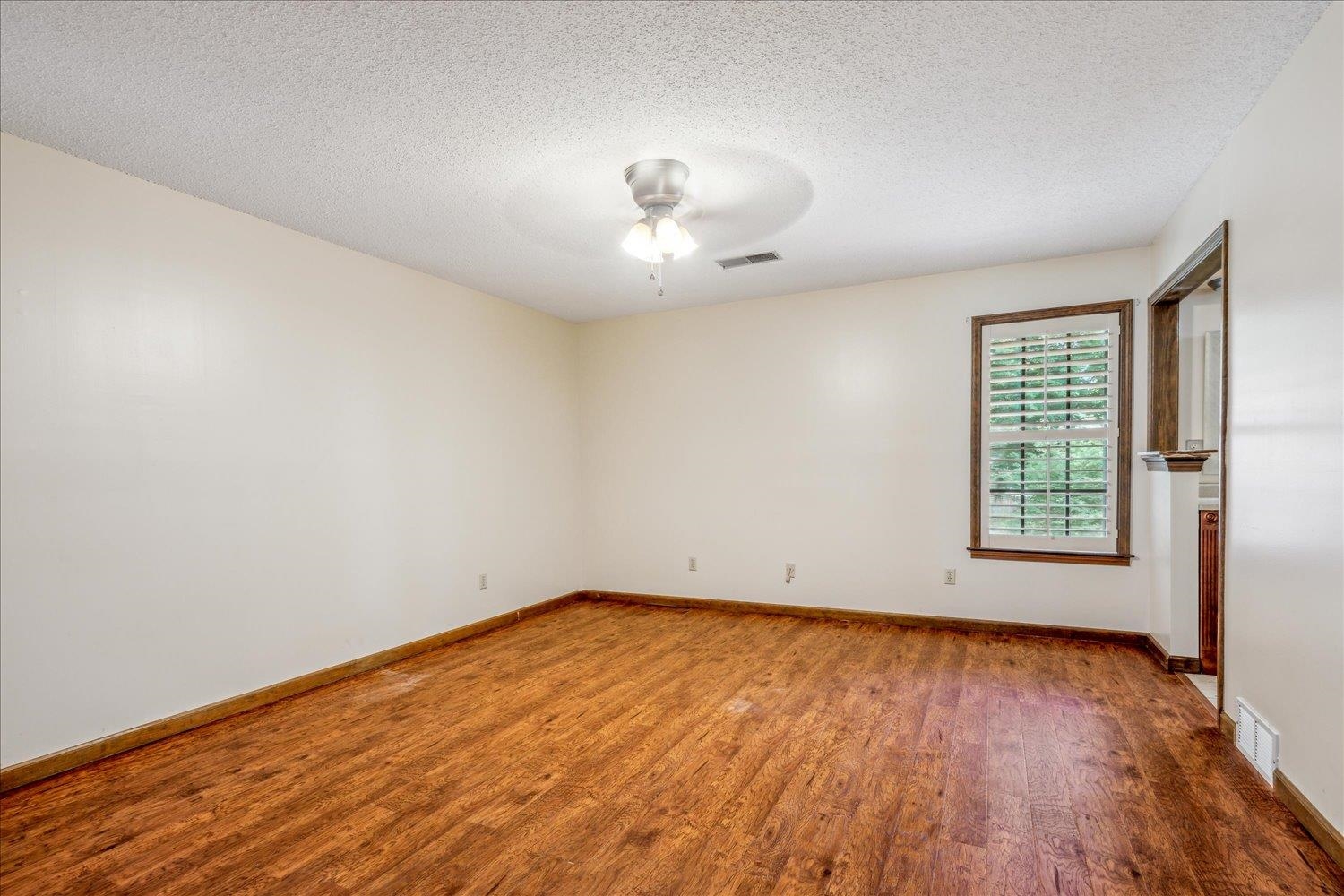 354 College Street Collierville, TN 38017 - Photo 17 of 33 an empty room with wooden floor and windows