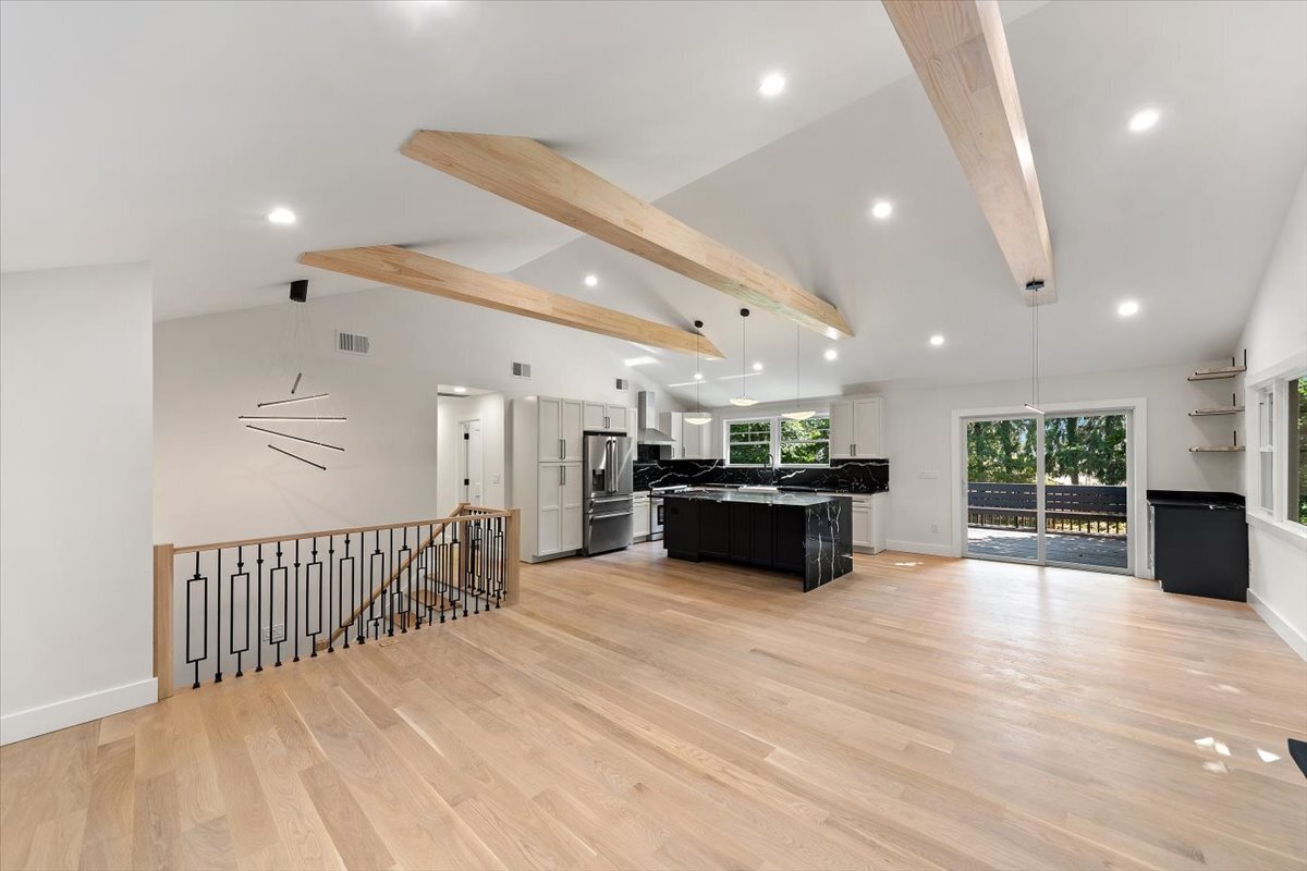 115 Mayfair Road Fairfield, CT 06824 - Photo 17 of 36 a large room with kitchen island a stove a chandelier and a wooden floor