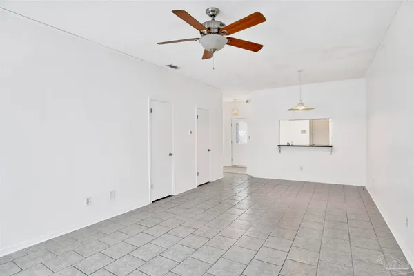 an empty room with ceiling fan and window
