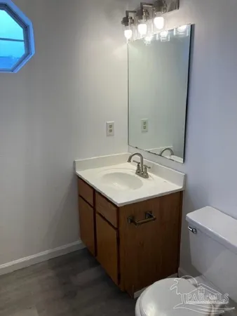 a bathroom with a sink vanity and toilet