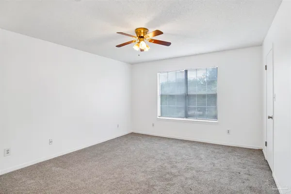an empty room with a window and a ceiling fan