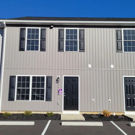a front view of a house with a parking space
