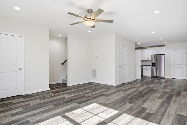 a view of an empty room with window and wooden floor
