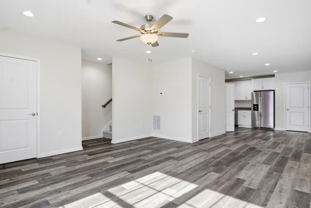 a view of an empty room with window and wooden floor