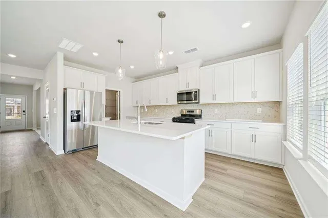 a kitchen with white cabinets and white appliances
