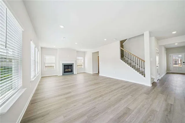 an empty room with wooden floor and fireplace