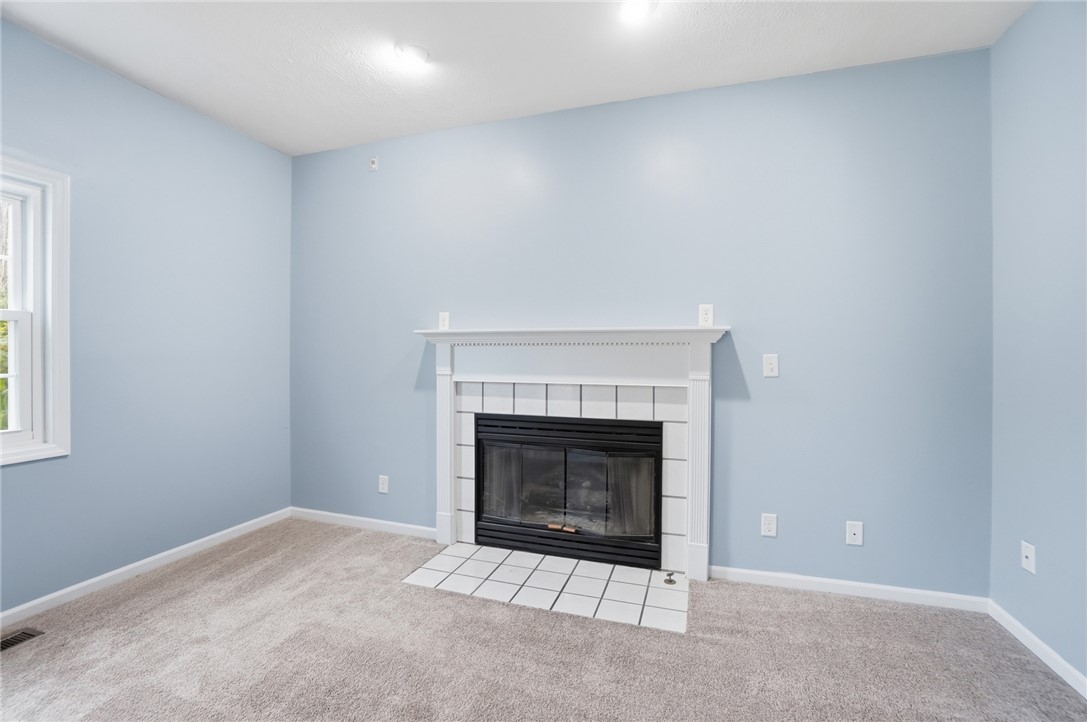 10 Chase Court Springboro, OH 45066 - Photo 14 of 75 This cozy living space features a tiled fireplace, offering comfort and charm.