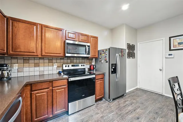 a kitchen with stainless steel appliances granite countertop a refrigerator stove and sink
