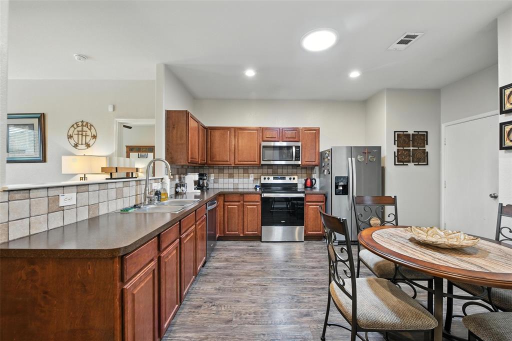 5817 Deck House Road Fort Worth, TX 76179 - Photo 16 of 28 a kitchen with stainless steel appliances kitchen island granite countertop a refrigerator a stove top oven a sink dishwasher and white countertops with cabinets