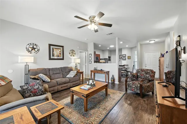 a living room with furniture kitchen view and a window