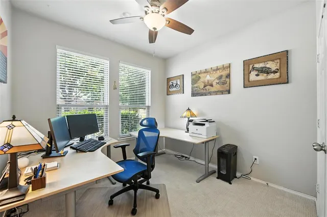 a view of a workspace with furniture and a window