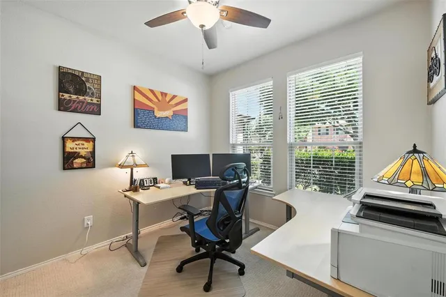 a view of a workspace with furniture and a window