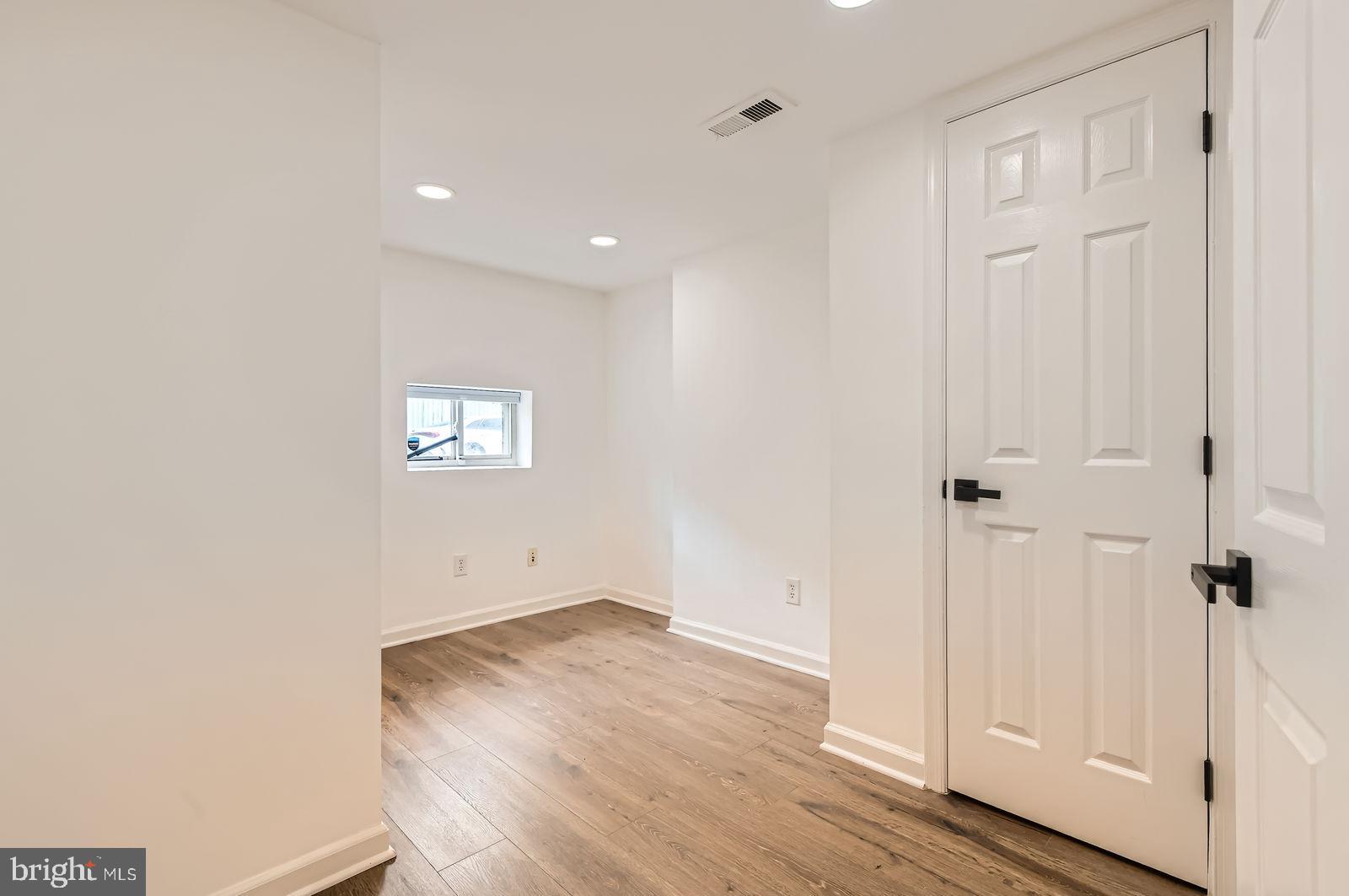 1440 Ward Street Baltimore, MD 21230 - Photo 20 of 27 an empty room with wooden floor and windows