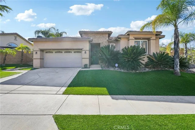 a view of a house with a yard and palm trees