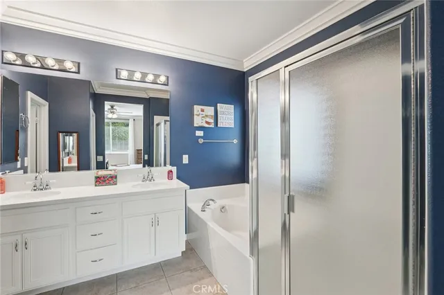 a en suite bathroom with a double vanity sink a large mirror a shower and a bathtub