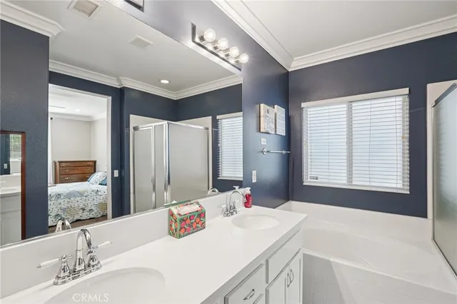 a en suite bathroom with a double vanity sink and a mirror