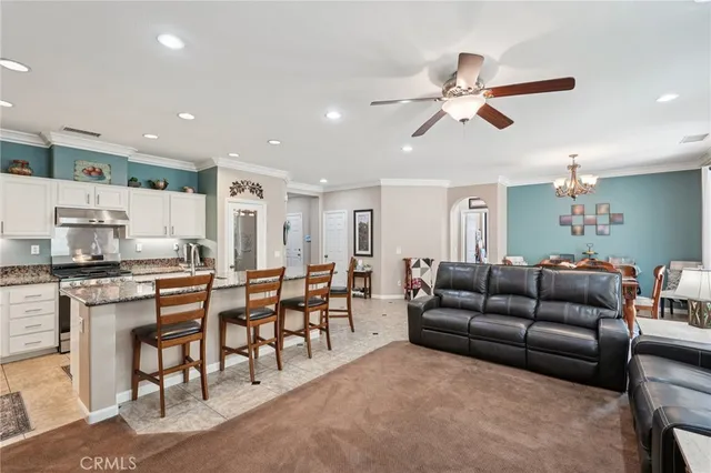 a living room with stainless steel appliances kitchen island granite countertop furniture and a couch