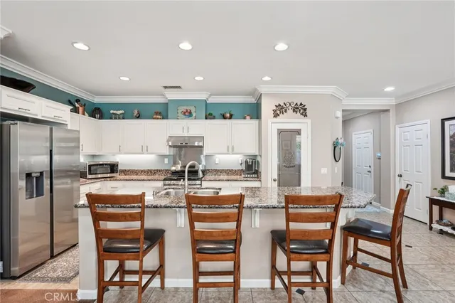 a kitchen with refrigerator a table and chairs