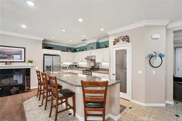 a kitchen with stainless steel appliances kitchen island granite countertop a table and chairs in it