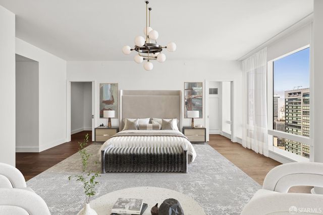 a bedroom with a bed couches and a chandelier