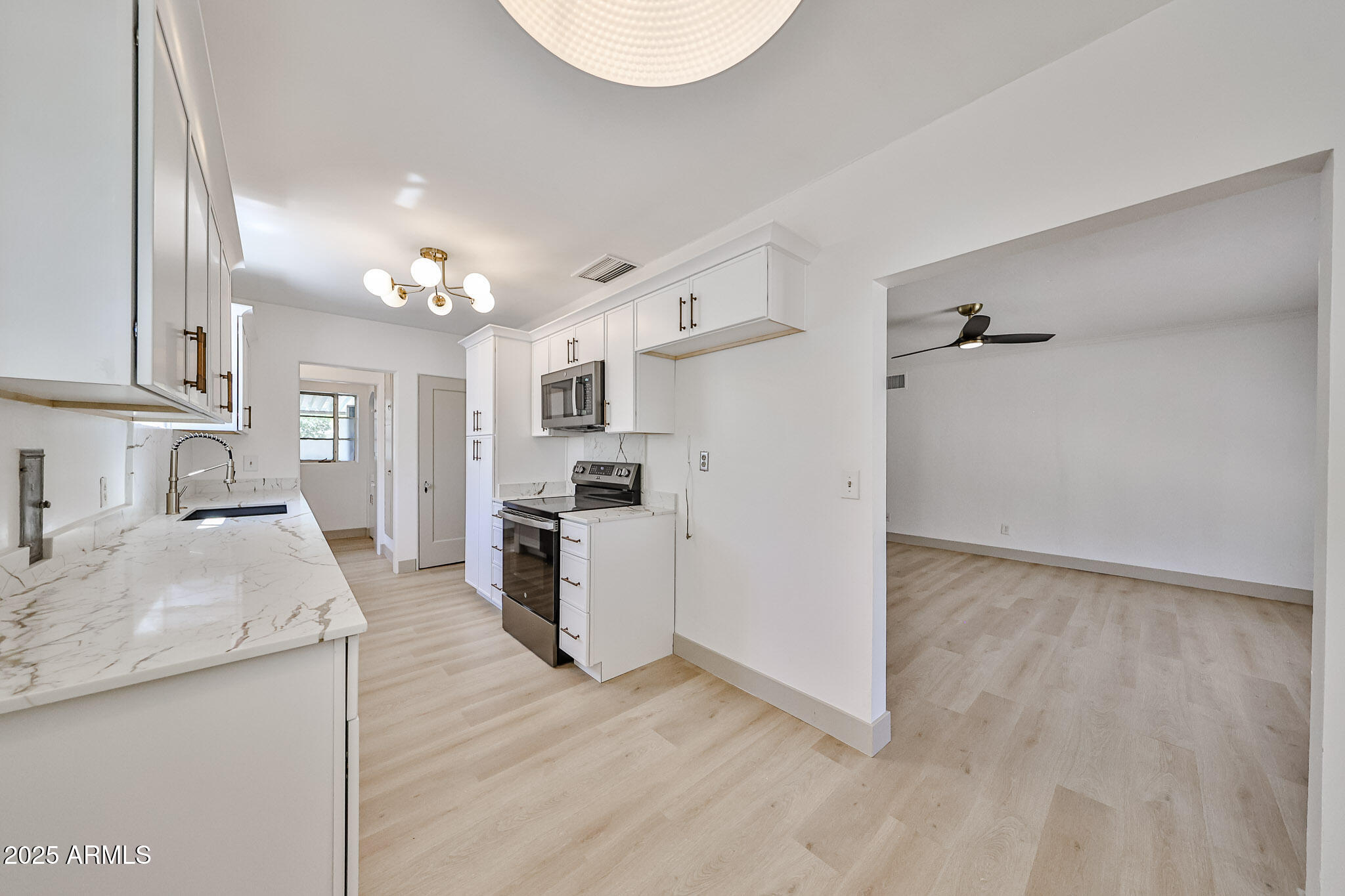 63 West Windsor Avenue Phoenix, AZ 85003 - Photo 15 of 43 a kitchen with granite countertop a refrigerator oven a sink dishwasher and white cabinets with wooden floor