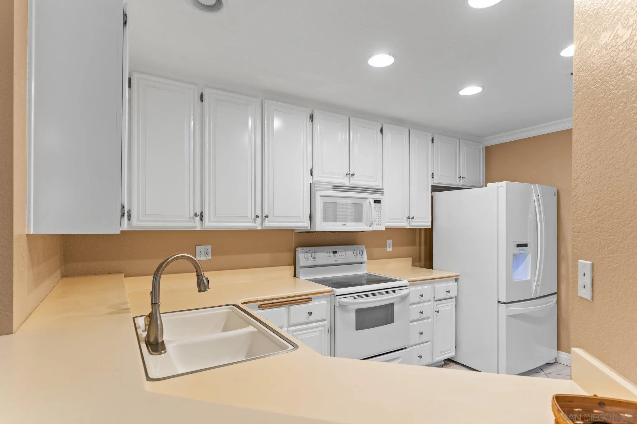 13801 Pinkard Way, Unit 8 El Cajon, CA 92021 - Photo 16 of 29 a kitchen with stainless steel appliances granite countertop a refrigerator sink and white cabinets