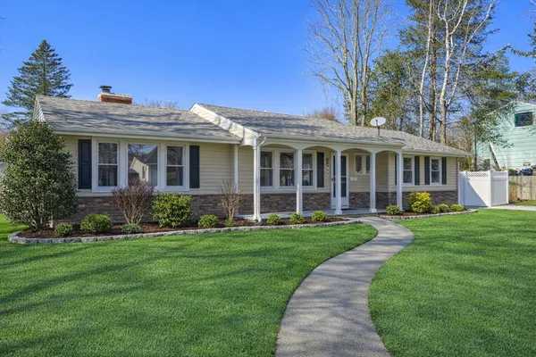 front view of a brick house with a yard