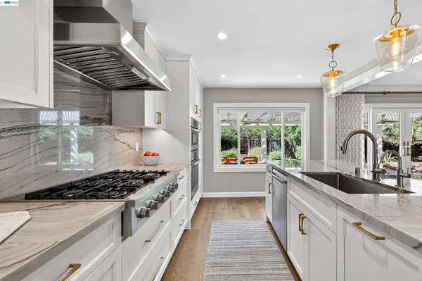 a kitchen with stainless steel appliances granite countertop a sink stove and cabinets