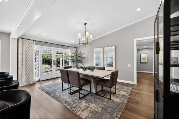 a dining room with wooden floor a chandelier a glass table and chairs