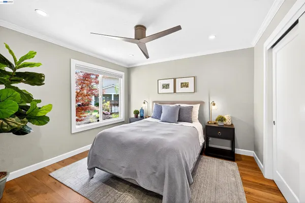 a bedroom with a bed painting on wall and a potted plant